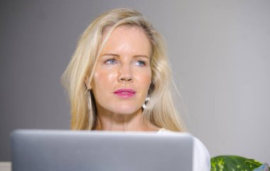 güzel portresi ve mutlu zarif sarışın kadın erken 40s evde rahat oturma odası yaşam tarzı kavramında rahat çalışma dizüstü bilgisayarda internet kullanımı kapat