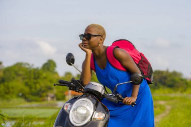Genç güzel ve macera seyahat ve yaz tatili scooter motosiklet yeşil alan tropikal peyzaj ile etrafa mutlu turist Afro-Amerikan siyah kadın kavramı seyahat