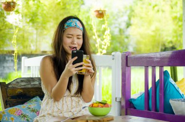 genç çekici ve mutlu Asian açık havada çalışan dijital göçebe gibi online sosyal medya blogger seyahat notları başarı iş yazma dizüstü bilgisayar ile rahat Korece