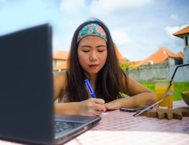 genç çekici ve mutlu Asian açık havada çalışan dijital göçebe gibi online sosyal medya blogger seyahat notları başarı iş yazma dizüstü bilgisayar ile rahat Korece