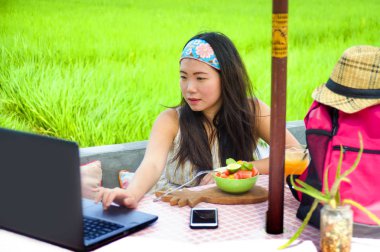 genç çekici ve mutlu Asian açık havada çalışan dijital göçebe başarı iş online sosyal medya backpacker seyahat blogcu olarak tropikal kafede dizüstü bilgisayar ile rahat Korece