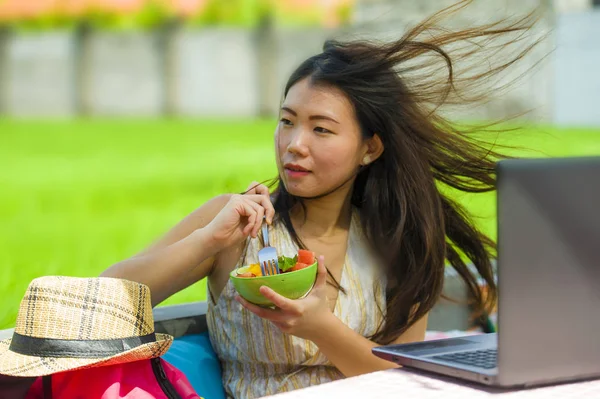 genç çekici ve mutlu Asian açık havada çalışan dijital göçebe gibi internet sosyal medya blogger seyahat başarı iş sağlıklı salata yemek dizüstü bilgisayar ile rahat Çin