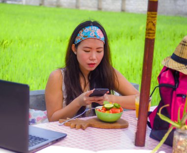 mutlu genç ve oldukça dijital göçebe Asyalı Koreli kadın meyve salatası cep telefonu ağ ile Internet sosyal medyada sağlıklı beslenme ve seyahat blogger Gıda çekim gözden geçirin