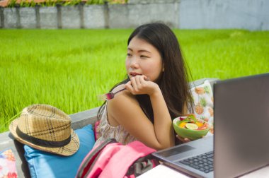 Genç güzel ve mutlu Asya dijital göçebe veya açık havada sağlıklı salata Internet serbest iş iş ve yaşam tarzı kavramı içinde zevk dizüstü bilgisayar ile ağ Çinli turist kadın