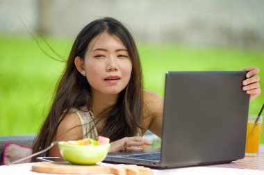 Genç güzel ve mutlu Asya dijital göçebe veya Internet serbest iş iş ve yaşam tarzı kavramı içinde dizüstü bilgisayar ile düşünceli açık havada ağ Koreli turist kadın