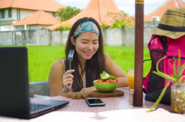 Genç güzel ve mutlu Asya dijital göçebe ya da Çinli turist kız açık havada sağlıklı salata Internet serbest iş iş ve yaşam tarzı kavramı içinde zevk dizüstü bilgisayar ile ağ