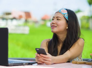 Genç güzel ve mutlu Asya dijital göçebe veya açık havada dizüstü bilgisayar ve Internet serbest iş iş yaşam tarzı kavramı içinde hareket eden telefon ile ağ Çinli turist kadın