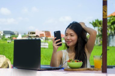 Genç güzel ve mutlu Asya dijital göçebe veya açık havada dizüstü bilgisayar ve cep telefonu Internet serbest iş iş ve yaşam tarzı ile ağ Çinli turist kadın 