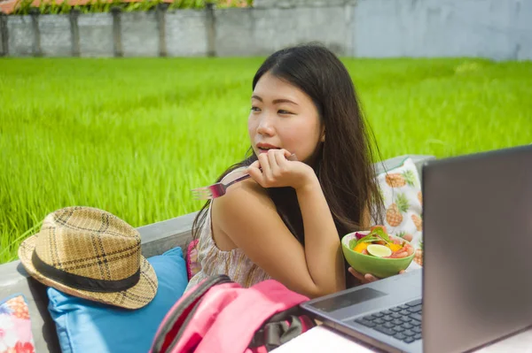 Genç güzel ve mutlu Asya dijital göçebe veya açık havada sağlıklı salata Internet serbest iş iş ve yaşam tarzı kavramı içinde zevk dizüstü bilgisayar ile ağ Çinli turist kadın