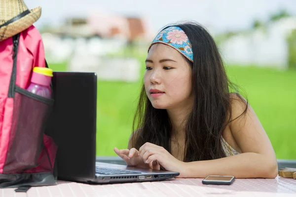 Genç güzel ve mutlu Asya dijital göçebe veya Koreli turist kız açık havada Internet serbest iş iş ve yaşam tarzı kavramı içinde dizüstü bilgisayar ile ağ