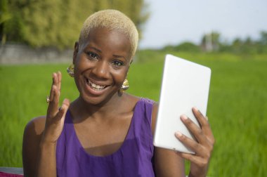 Tablet pad açık havada yeşil alan arka plan dijital göçebe başarı ve online sosyal medya eğlence neşeli gülümseyen tarih kullanan genç çekici ve mutlu başarılı siyah afro Amerikan kadın