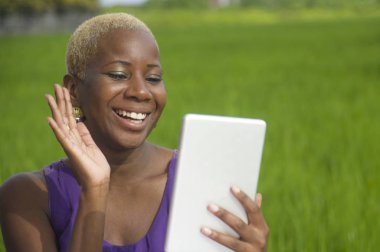 Tablet pad açık havada yeşil alan arka plan dijital göçebe başarı ve online sosyal medya eğlence neşeli gülümseyen tarih kullanan genç çekici ve mutlu başarılı siyah afro Amerikan kadın