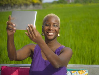 selfie dijital tablet pad ile zevk yaz tatil tropikal hedefte seyahat yeşil çim alan arka plan açık havada alarak genç çekici ve mutlu siyah Afrikalı-Amerikalı kadın