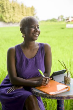Online dijital tablet pad ile açık havada yeşil çim alan seyahat blogger ve dijital göçebe iş kavramı neşeli gülümseyen üzerinde çalışan 18young çekici ve mutlu siyah Afrikalı-Amerikalı kadın