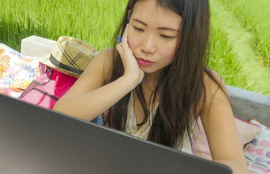 Açık havada yeşil çim arka plan dijital göçebe ve Internet serbest iş kavramı kafede ağ dizüstü bilgisayar ile çalışan genç güzel ve mutlu Asyalı Koreli kadın