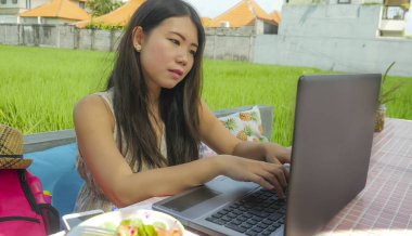 Açık havada yeşil çim arka plan dijital göçebe ve Internet serbest iş kavramı kafede ağ dizüstü bilgisayar ile çalışan genç güzel ve mutlu Asyalı Koreli kadın