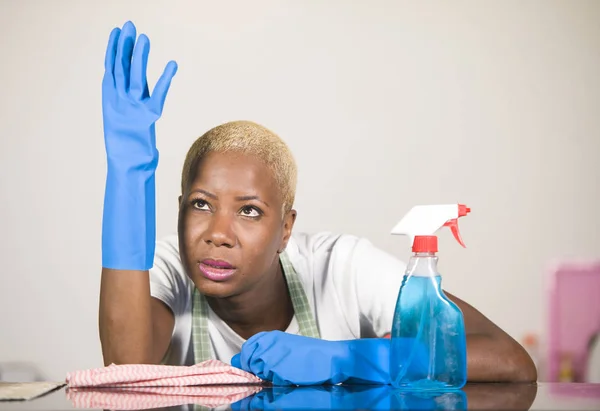 young attractive stressed and upset back african American woman in washing rubber gloves cleaning home kitchen tired and overworked in domestic work housekeeping and housewife stress