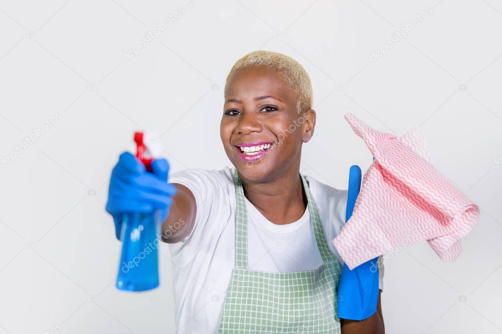 young beautiful and happy black afro american woman using detergent spray bottle as gun smiling playful cleaning and washing home kitchen isolated on white background in housework concept