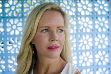 güzel ve rahat Kafkas portresi yakın seyir mavi gözlü sarışın kadın uzak izole dalgın ve düşünceli poz bir mavi model arka plan üzerinde 