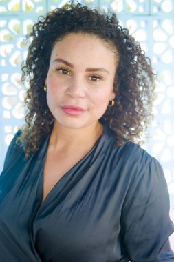 Genç güzel ve mutlu latin afro onu 30s açık havada güzel arka planda mutluluk ve başarı kavramı üzerinde izole baştan çıkarıcı ve poz taze gülümseyen kadın karışık.