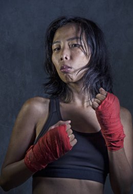 Eğitim mma mücadele spor veya tehlikeli karanlık grunge arka plan üzerinde izole badass poz arayan boks egzersiz bilek kullanarak sportif ve uygun savaşçı Asyalı Çinli kadın portresi sarar