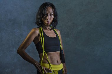 portre genç atletik ve fit spor salonu spor egzersiz kavramı koyu arka plan üzerinde Asyalı Koreli kadın fitness üst holding serin kötü kız meydan okuyan tutumunda poz ip atlama içinde izole