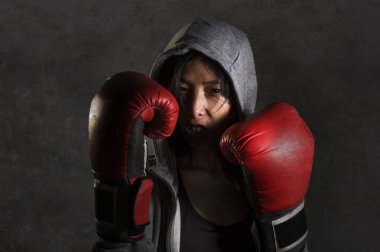 Genç zinde ve sağlıklı Asyalı Çinli boksör kadın fitness üst hoodie ve boks eldivenleri serin badass tutumu kızgın ve karanlık izole mücadele egzersiz meydan okuyan poz portresi kapatın 