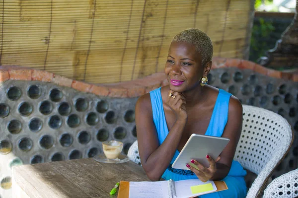 Dijital tablet pad ağ mutlu ve neşeli internet online iş ve girişimci başarı kullanarak trendy kahve dükkanında çalışan genç şık ve zarif siyah Afrika kökenli Amerikalı iş kadın