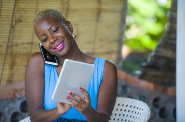 cep telefonu dijital tablet pad Internet freelancer iş başarı kavramı içinde ağ iletişimi sırasında konuşurken kahve dükkanında çalışan genç güzel mutlu ve yoğun siyah afro Amerikan kadın portresi