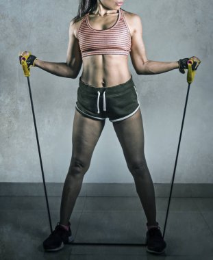 Yüzsüz genç portresi uygun ve sağlıklı yaşam konsepti gri arka plan üzerinde atletik spor kadın fitness egzersiz eğitim elastik direnç gruplarla çalışkan izole