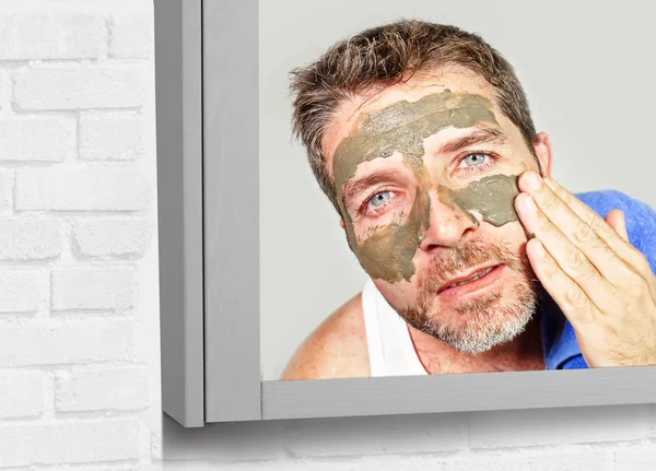 皮膚に適用する顔マスク緑クリームと浴室タオルを持つ魅力的で幸せな若者のライフ スタイル ミラー肖像画気に美しさと男性化粧品の利用の概念 — ストック写真