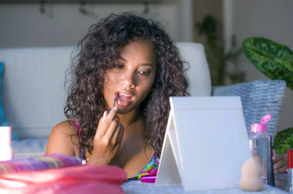 Estilo de vida retrato de joven feliz y hermosa mujer latinoamericana cuidadosamente utilizando lápiz de brillo de labios aplicando maquillaje de la cara mirando el espejo — Foto de Stock