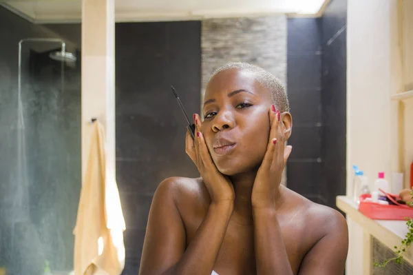 ライフ スタイル自然女性の肖像若い魅力的で幸せな黒アフロ アメリカン ホーム浴室トイレ鏡にこにこしている新鮮な探してマスカラーまつげ鉛筆で顔メイクを適用することを — ストック写真