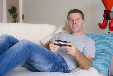 ev salon koltuk kanepe online oyun kavramında heyecanlı eğleniyor konsol denetleyici tutan video oyunu oynarken zevk genç çekici ve mutlu adam portresi yaşam tarzı