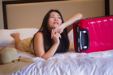 Genç mutlu ve güzel yaşam tarzı portresi Asya turizm seyahat bavul kadınla yatakta zevk oynarken beş yıldızlı bir otel odasında geldi Korece yaz tatil gezisi heyecanlı.