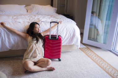 yaşam tarzı genç mutlu ve güzel Asya seyahat bavul gelen turistik kadınla, beş yıldızlı otel oda heyecanlı ve keyifli tatil kavramı içinde bakarak yorgun Korece doğal portresi