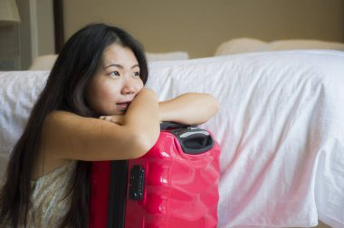 yaşam tarzı genç mutlu ve güzel Asya seyahat bavul gelen turistik kadınla, beş yıldızlı otel oda heyecanlı ve keyifli tatil kavramı içinde bakarak yorgun Korece doğal portresi