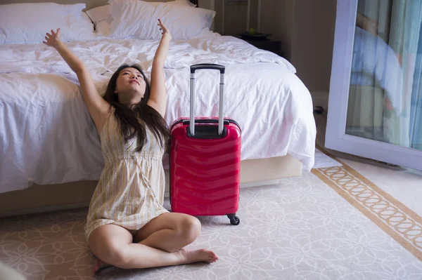 yaşam tarzı genç mutlu ve güzel Asya seyahat bavul gelen turistik kadınla, beş yıldızlı otel oda heyecanlı ve keyifli tatil kavramı içinde bakarak yorgun Korece doğal portresi