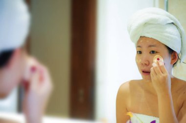 yaşam tarzı genç mutlu ve güzel Asyalı Çinli kadın evde veya otel banyo tuvalet havlu neşeli ve kadın güzellik ve cilt bakımı doğal makyaj uygulamak sarılı taze portresi 