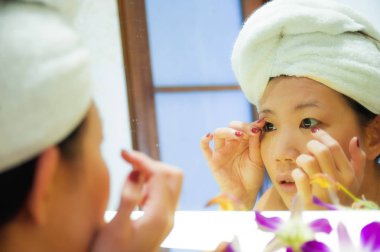 yaşam tarzı genç mutlu ve güzel Asyalı Çinli kadın evde veya otel banyo tuvalet havlu neşeli ve kadın güzellik ve cilt bakımı doğal makyaj uygulamak sarılı taze portresi