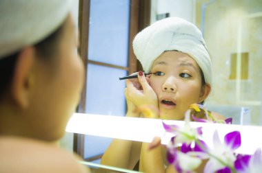 yaşam tarzı genç mutlu ve güzel Asyalı Çinli kadın evde veya otel banyo tuvalet havlu neşeli ve kadın güzellik ve cilt bakımı doğal makyaj uygulamak sarılı taze portresi