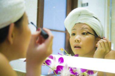 yaşam tarzı genç mutlu ve güzel Asyalı Çinli kadın evde veya otel banyo tuvalet havlu neşeli ve kadın güzellik ve cilt bakımı doğal makyaj uygulamak sarılı taze portresi