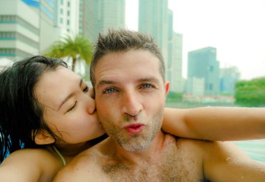 Genç ve çekici mutlu oynak çift selfie fotoğrafını cep telefonu ile birlikte tatil balayı zevk lüks kentsel otel sonsuzluk havuzu çeşitlilik etnisite ve aşk bir yolculuk