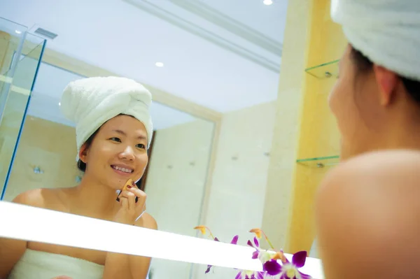 若い幸せで 美しいアジア中国の女性自宅またはホテルのバスルームは明るく自然な女性の美しさとスキンケアでメイクを適用するトイレのタオルに包まれた肖像画を新鮮なライフ スタイル — ストック写真