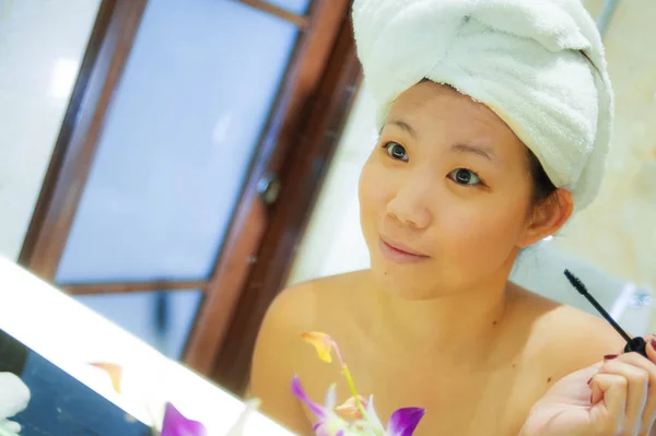 若い幸せで 美しいアジア韓国女性自宅またはホテルのバスルームは明るく自然な女性の美しさとスキンケアでメイクを適用するトイレのタオルに包まれた肖像画を新鮮なライフ スタイル — ストック写真