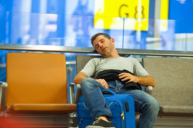 yaşam tarzı portre havaalanında genç çekici ve yorgun turist adamın yatılı kapısında bekleyen için uyku çanta iptal veya hava ulaşım kavramı tatil seyahat için hazır uçuş gecikmeli