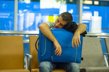 yaşam tarzı portre havaalanında genç çekici ve yorgun turist adamın yatılı kapısında bekleyen için uyku çanta iptal veya hava ulaşım kavramı tatil seyahat için hazır uçuş gecikmeli