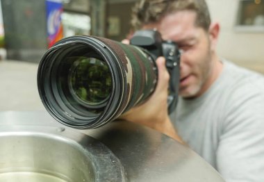 Kentsel arka plan yaşam tarzı genç paparazzi fotoğrafçı adam şehir kağıt basket özel fotoğraf hikaye ünlü üzerinde çekim için takip arkasında gizli eylem komik portresi 