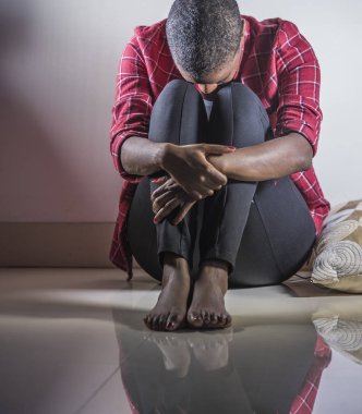 yaşam tarzı kapalı gölgeli katta umutsuz ve acı acı ve depresyon dramatik ışık endişeli hissediyorum evde oturan genç üzgün ve depresyonda siyah Afrikalı-Amerikalı kadın portresi