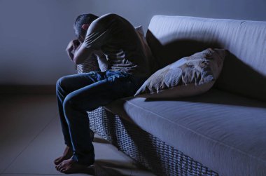 ağrı ve stresli hissediyor depresyon ve umutsuz yalnız acı anksiyete krizi ağlıyor gölgeli ev kanepe oturma üzgün ve depresyonda delikanlı yaşam tarzı dramatik ışık portresi